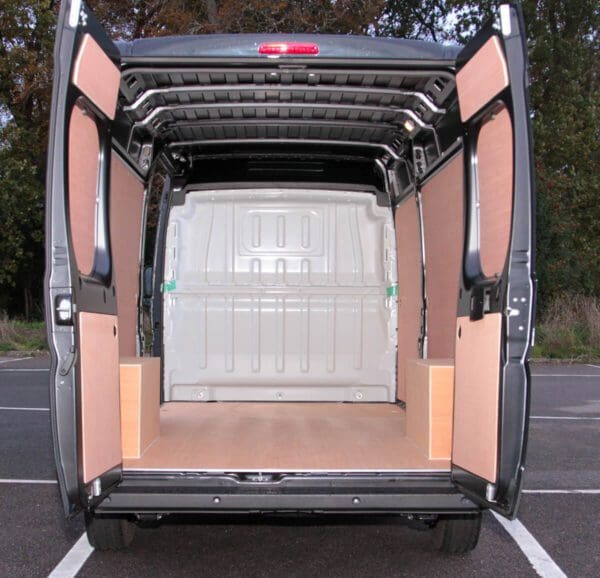 A van with the back door open and some wood panels on it.