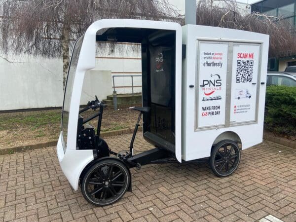 A white cart with a bicycle in the front.