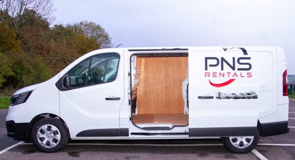 A white van with the door open and a wooden panel on it.